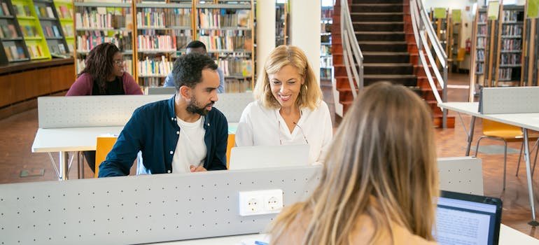 Students working on laptop in a library