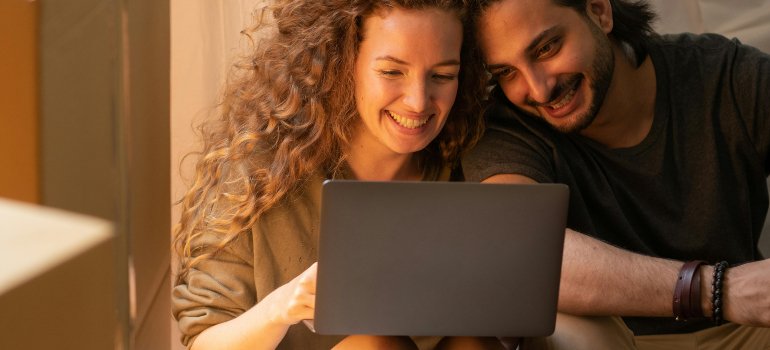 A couple searching for tips for organizing a self storage unit for frequent access on the laptop.
