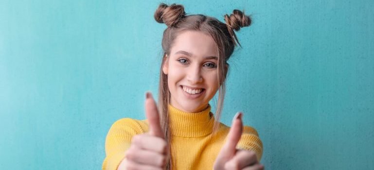 A young girl showing thumbs up.