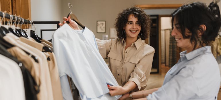 Two friends discussing how to store hanging clothing in a mini storage unit