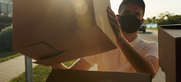 A man loading moving boxes into the truck