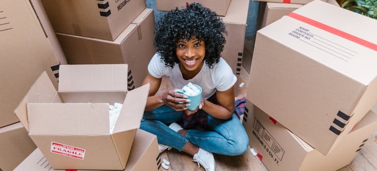 A girl in sitting among moving boxes before handling expensive paintings between relocations