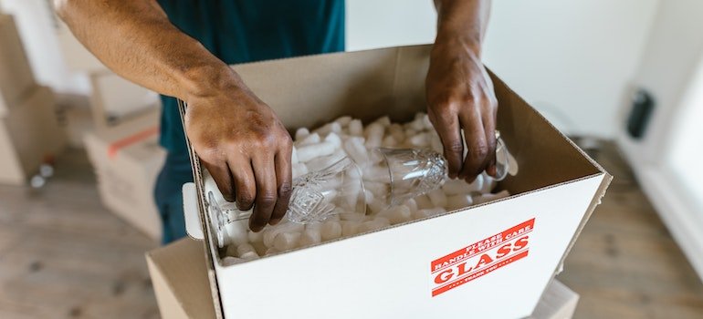 A man putting two glasses in a box