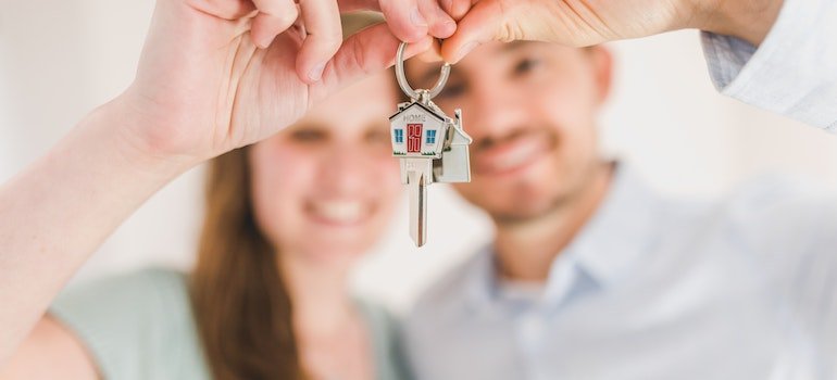A couple holding a house key after finding storage solutions for newlywed couples in Manhattan