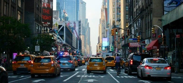 Taxis, cars and people in Manhattan during the day