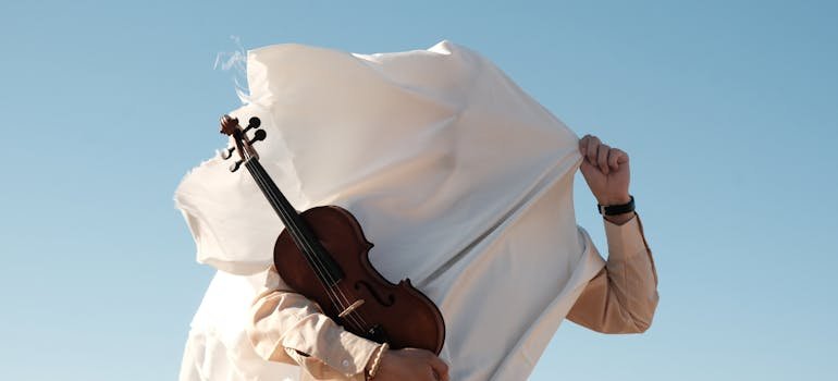 A man trying to cover a violin with a white cloth