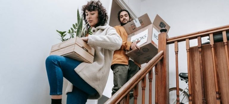 A man and a woman carrying boxes to long-term storage in the Bronx