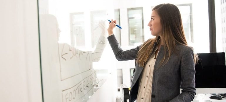 A woman writing on a board about business opportunities for new residents in NYC