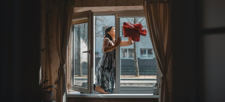 A woman Cceaning a window.