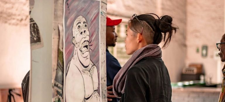 People walking around at an event, looking at art and talking about ccreative uses for storage units in NYC