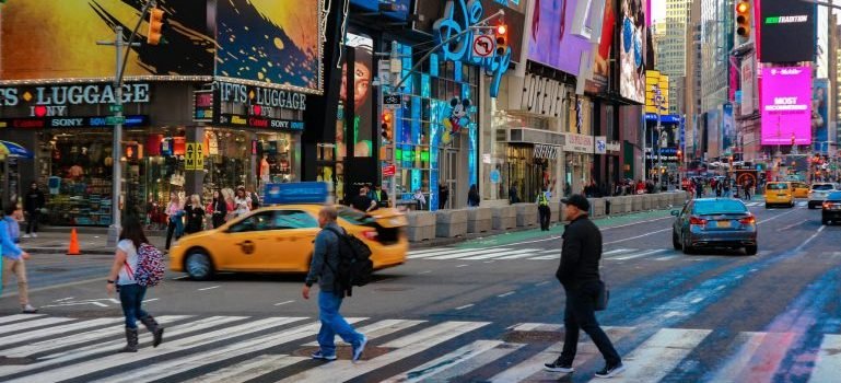 People walking on the crosswalk and thinking about the most challenging aspects of living in Manhattan.