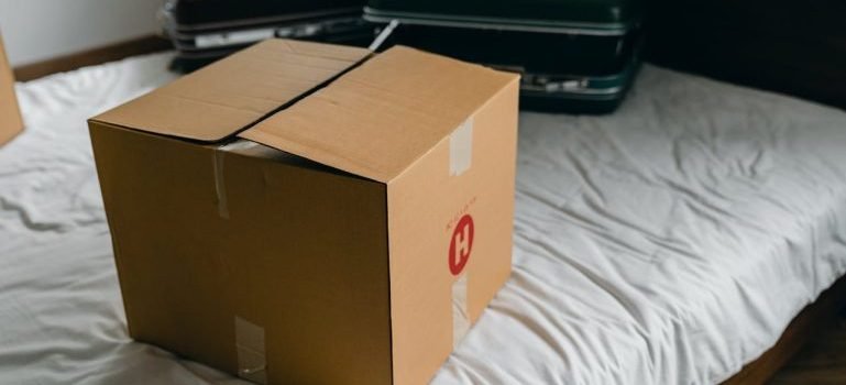 A cardboard moving box on the bed