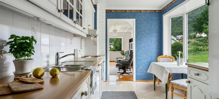 Kitchen interior with white furniture and a blue wall.