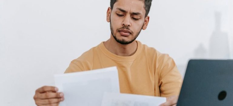 A man looking at white paper to select which items are going to be stored at the long-term storage in the Bronx
