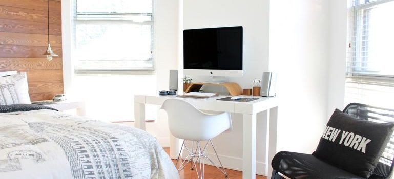 A big bedroom with a tv and a black chair.