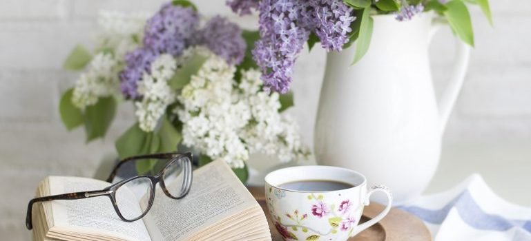 A book, flowers and coffee on the table for a break after arranging your new Bronx home.