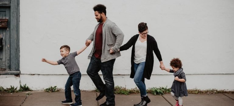 A family walking and holding with their hands.