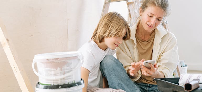 A woman and a boy reading on a cell phone about redesigning your living space.