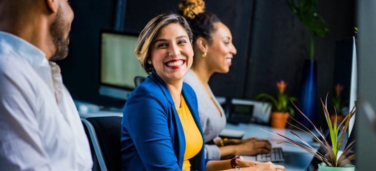 A woman at work smiling with her coworkers.