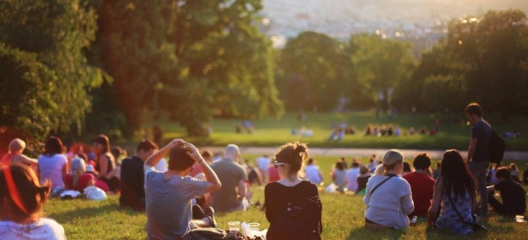 People sitting on the grass in the park in one of the Bronx neighborhoods with the lowest crime rates