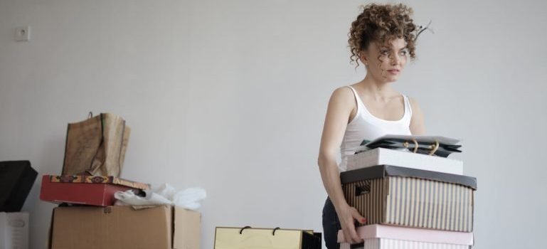 A woman holding a box while trying to maintain her Manhattan apratment clutter-free