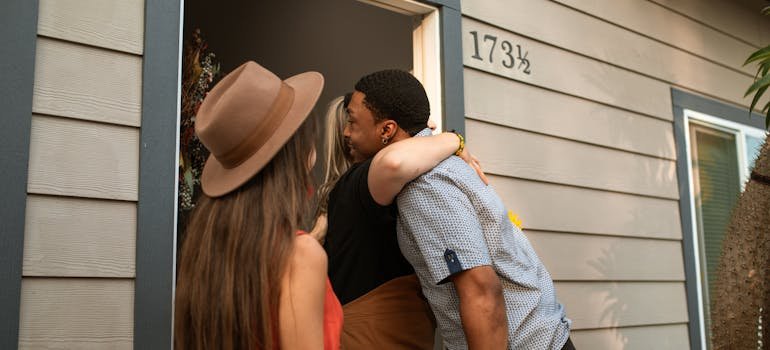 A woman hugging a man at the doorstep.