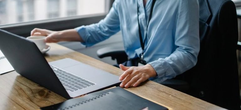 A man sitting at the desk and a laptop in front of him