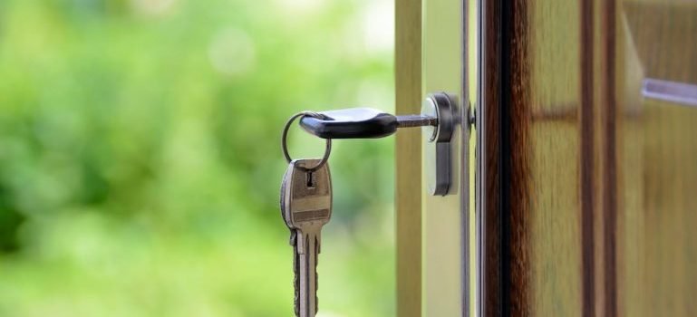 A key in the lock of an open door after finding a cheap rental in Manhattan.