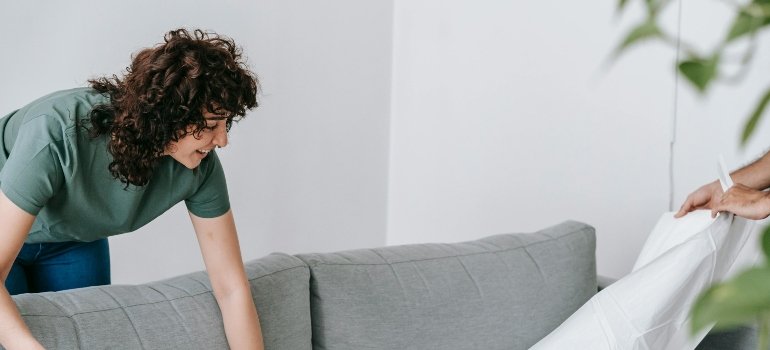 A woman leaning over a couch.