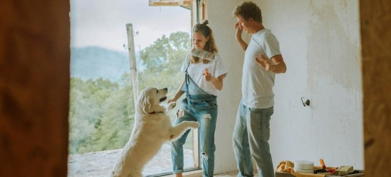 A couple playing with their dog in their new apartment in one of Manhattan's top dog-friendly neighborhoods.