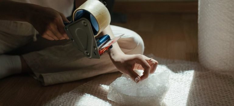 A woman using bubble wrap to pack and store camping gear