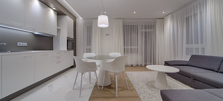 A contemporary living room with the kitchen after applying some minimalism design tips for NYC renters.