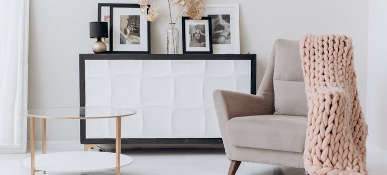 A beige sofa chair near a table as one of the minimalist design tips for NYC renters.