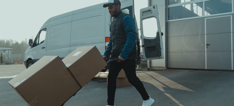 A man pulling large moving boxes.