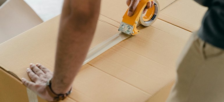 someone taping a cardboard box