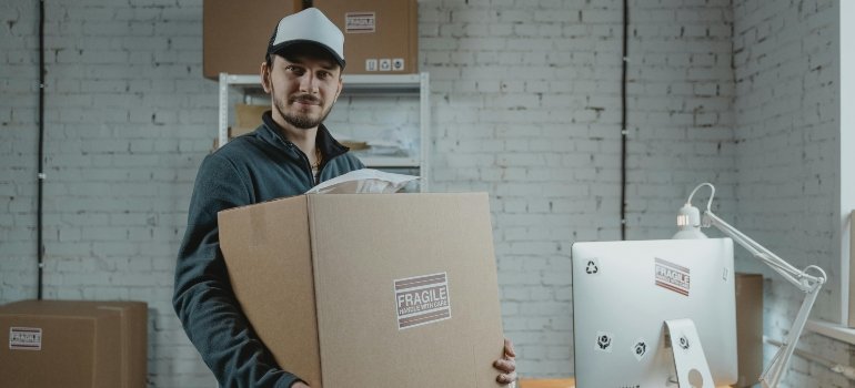 a man holding a box and Comparing renting storage and in-house storage solutions