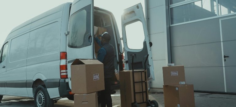 a mover standing behind a van and Comparing renting storage and in-house storage solutions