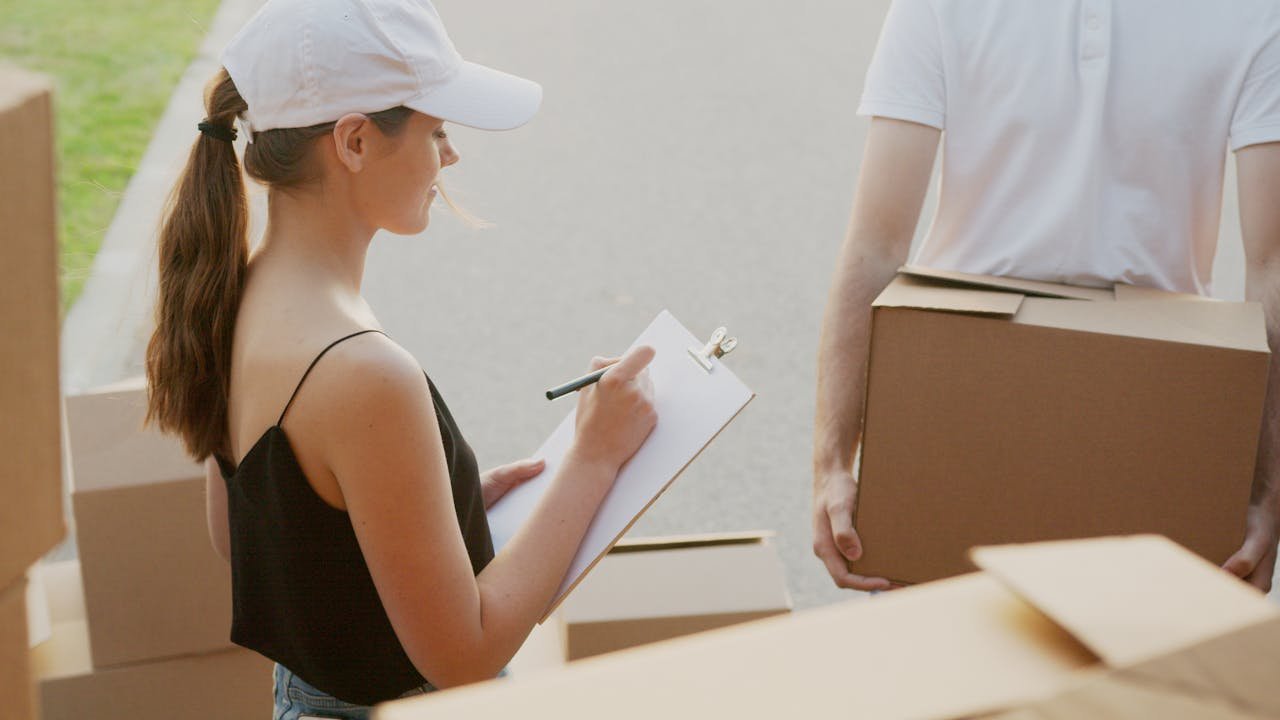 A woman making a list before taking items to storage.