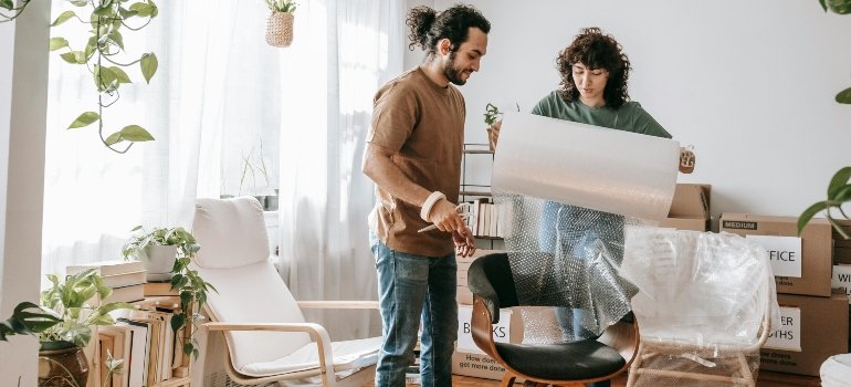 A couple packing up a chair.