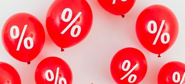 Red ballons in front of a white wall.