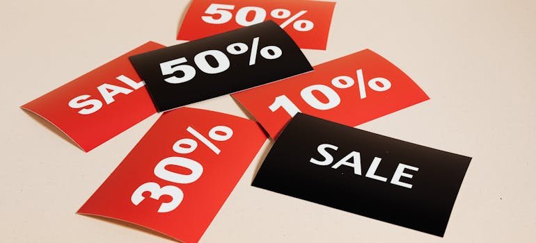 black and red discount tags on a beige surface