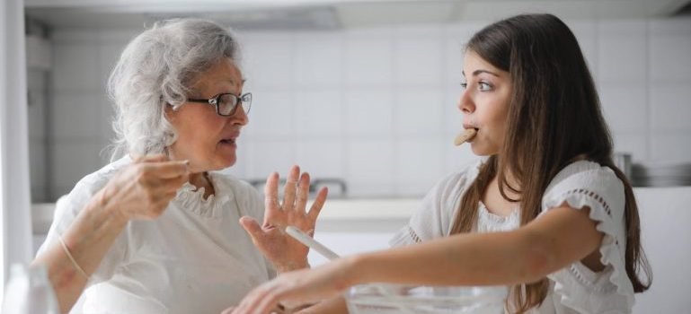 grandmother with granddaughter talking and eating cookies