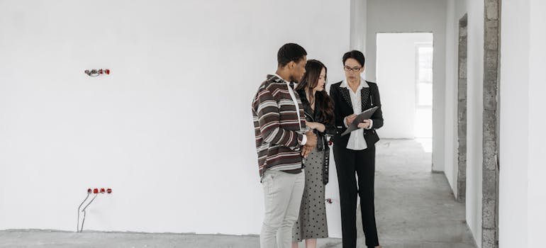 a couple talking to a real estate agent
