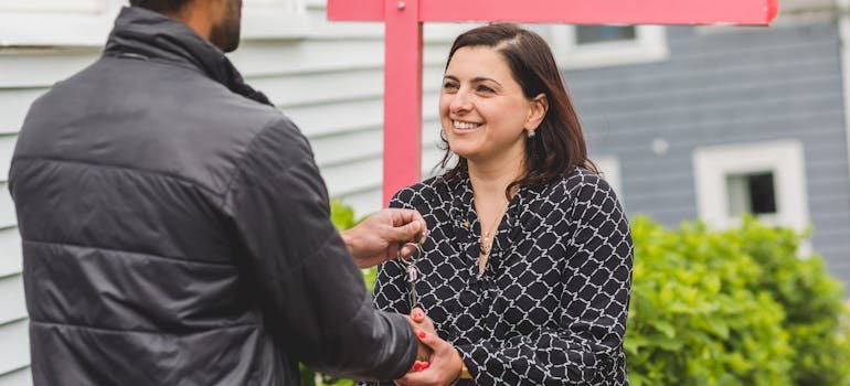 a woman shaking hands with a man wanting to buy a new home in NYC remotely