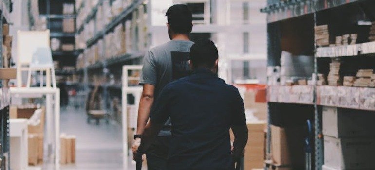 Two men in a storage facility.