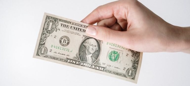 A person holding a paper bill.