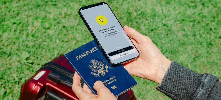A person looking at a US passport and a mobile phone.