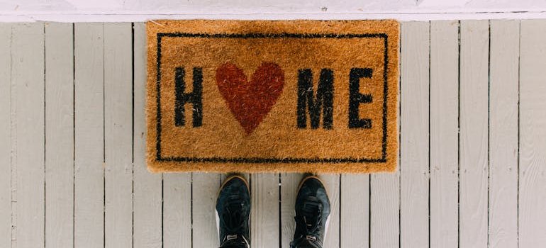 Doormat with a saying "HOME" in fornt of a home in one of the affordable NYC locations for first-time renters