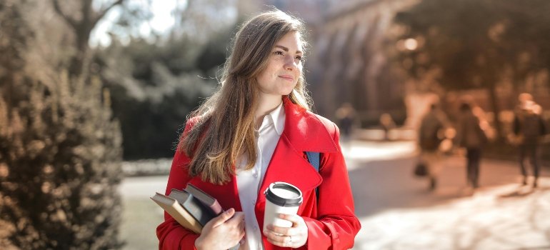 A woman in a red coat exploring the campus.