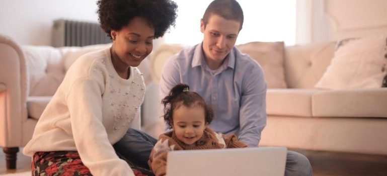Family using a laptop for research as you should do to discover which Brooklyn neighborhood is right for you.